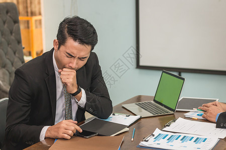 商人在工作桌上沉睡于使用智能手机商业概念图片