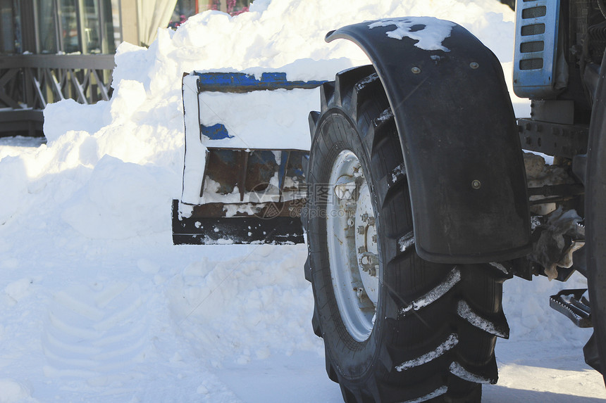 冬季在城市用推土机清理道路的雪图片