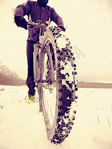 冬季骑自行车的赛车选手留在雪地上冬季极端运图片