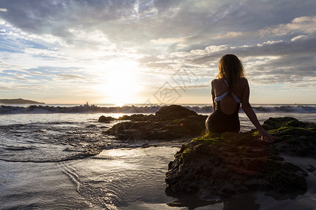 在哥斯达黎加PlayaFlammingo享受美丽日落的岩石上坐图片