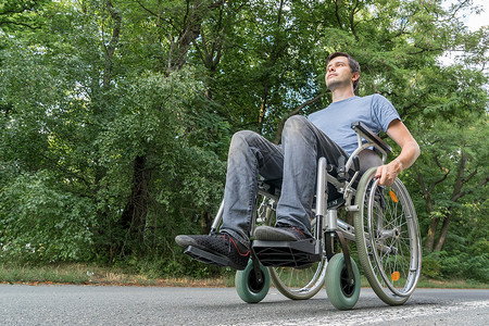 残疾或残疾青年男子坐在轮椅上图片