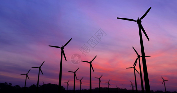 戏剧天空背景上的风力涡轮机剪影生态电力概念中的图片