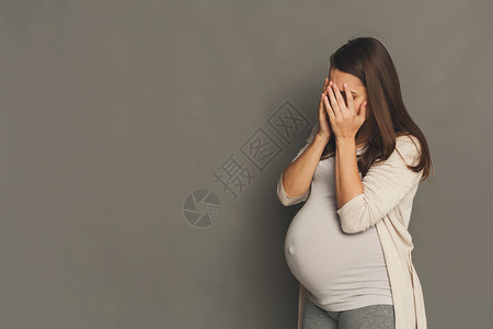 哭泣的孕妇肖像灰色工作室背景复制空间压抑的孕妇紧贴着脸部图片