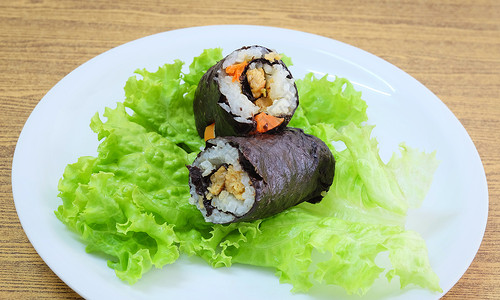 日本餐饮传统菜鸟日本大米玛吉寿司卷与豆腐和胡萝卜包装在绿橡树上NoriSea背景图片