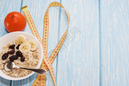 健康的早餐白碗里的葡萄干燕麦片明亮的橘子图片