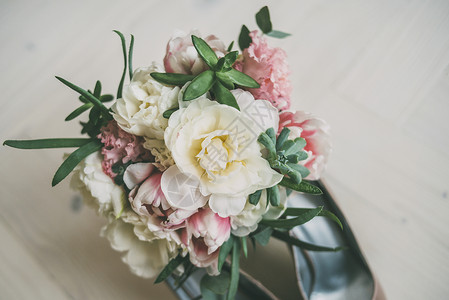 粉红色和米色鲜花和婚鞋的婚礼花束图片