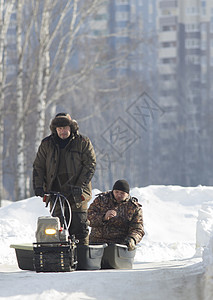 紧凑的打猎雪车摩托车拖着两个猎人在阳光明图片