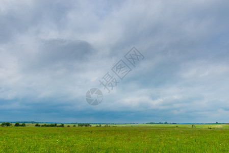 深雨云挂在乡村的绿色春田上图片