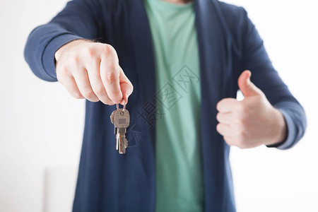 男人手握房钥匙的明亮照背景图片