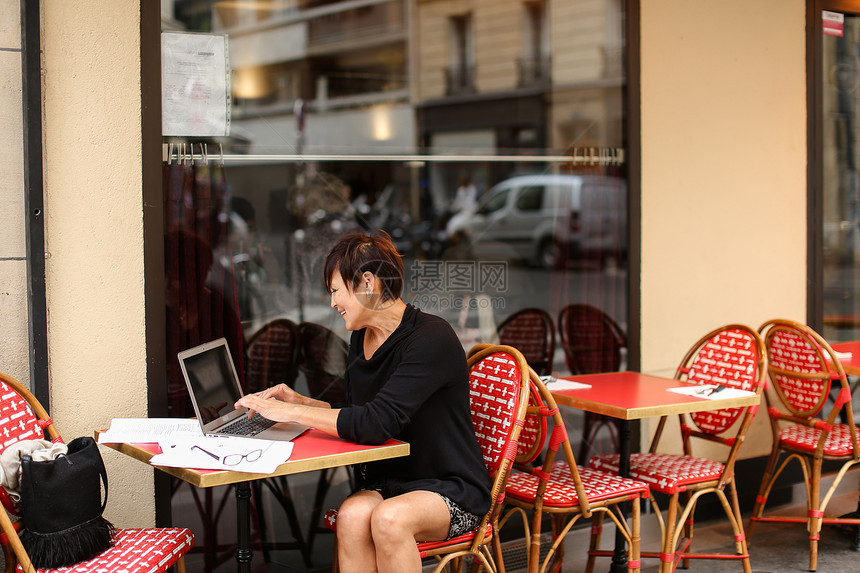 老年女编剧坐在户外咖啡馆里图片