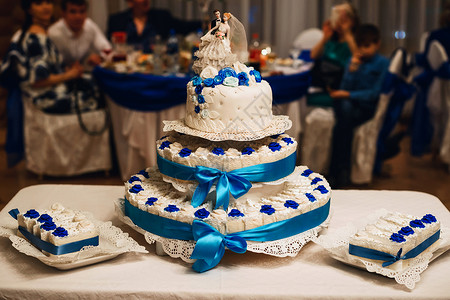 用蓝玫瑰装饰的婚礼白蛋糕三层蛋糕和新娘图片