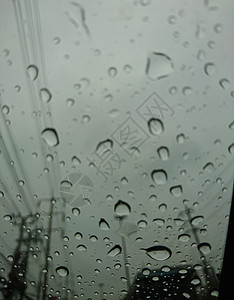 汽车玻璃上有雨滴从车内看到灰色天图片