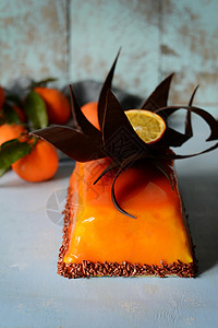 配香草奶油和橙色镜子的慕斯蛋糕巧克力装饰品甜图片