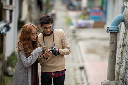 年轻亚洲情侣在参观小城市期间拍摄的图片时图片