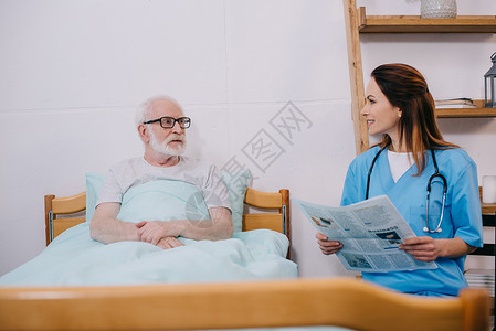护士给高级病人看报纸图片