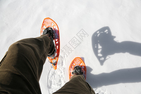 白雪上穿着灯芯绒长裤和雪鞋的男人背景图片