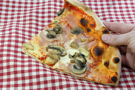 在意大利披萨店拿一块意大利比萨配奶油芝士蘑菇图片