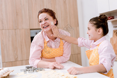 快乐的外祖母和小孙女在厨房做饭时图片