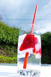 用冰块和吸管装在玻璃杯里的草莓饮料图片