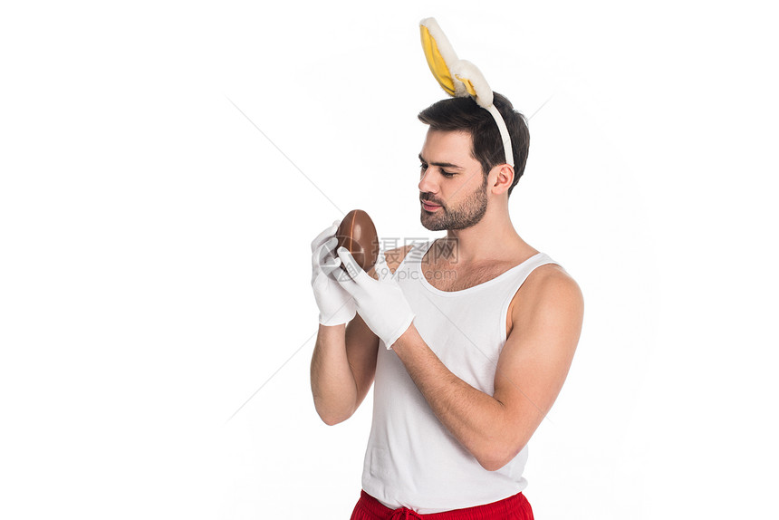 怀着兔子耳朵的男子拿着巧克力蛋在白色东西方图片