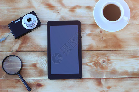 平板电脑相机和木桌上的一杯咖啡图片