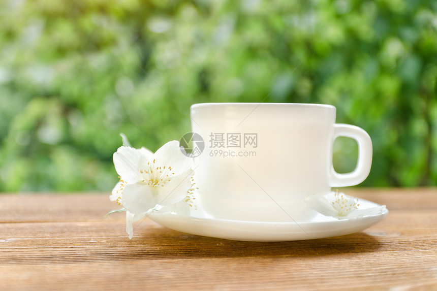 白茶杯子有茉莉花在背景绿图片