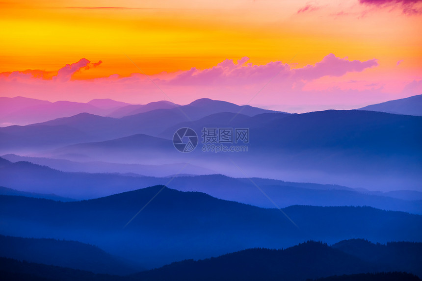 夕阳下蓝雾中的宁静山谷图片