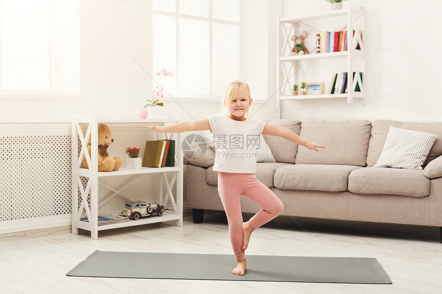 在家练习瑜伽的小女孩可爱的孩子在家里的垫子上做练习从童年概念开始的图片