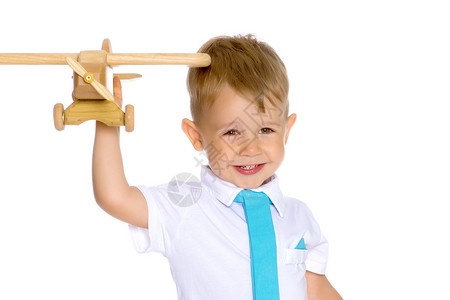 快乐的男孩玩木制玩具飞机孤图片