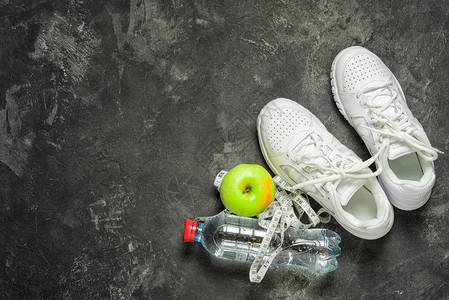 运动鞋一个苹果一厘米胶带和一瓶水图片