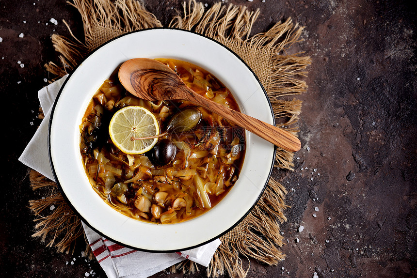 俄罗斯传统汤solyanka由菜新鲜和干燥的蘑菇以及橄榄柠图片