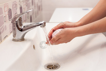 一个女人用肥皂洗手在浴室图片