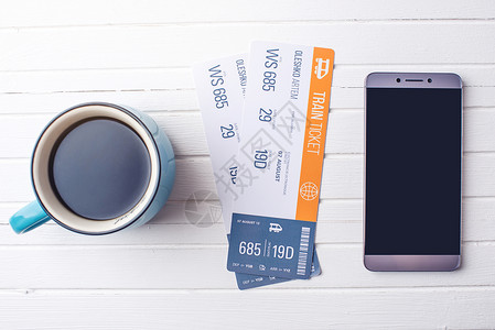 一杯咖啡火车票和白色木制背景上的电话购买在线机票预图片
