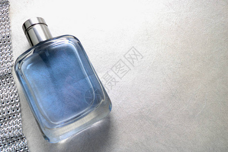 蓝色美丽的玻璃透明时尚迷人的古龙水瓶香水和闪发光的水钻丝带钻石和浅白色背景上简背景图片