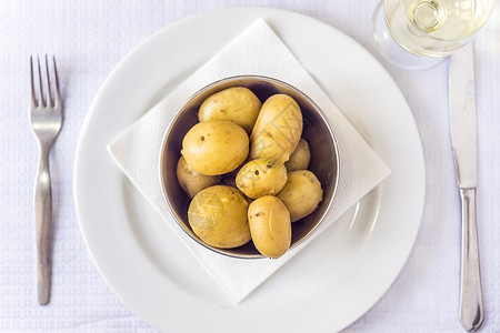 在银碗和白葡萄酒中煮熟的小土豆图片