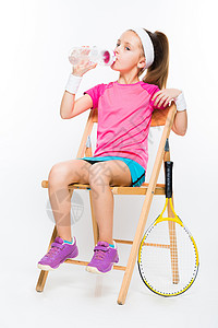 可爱的小网球运动员坐在木椅上喝水图片