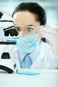 医学分析女科学家在实验室做测试使用显微镜图片