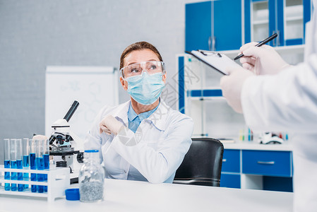 戴医用口罩和护目镜的科学家在实验室从事科学研图片