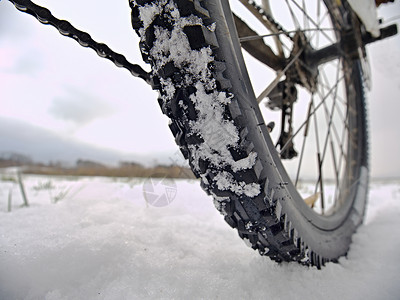 Mtb雪片在路边深处轮胎上融化背景图片