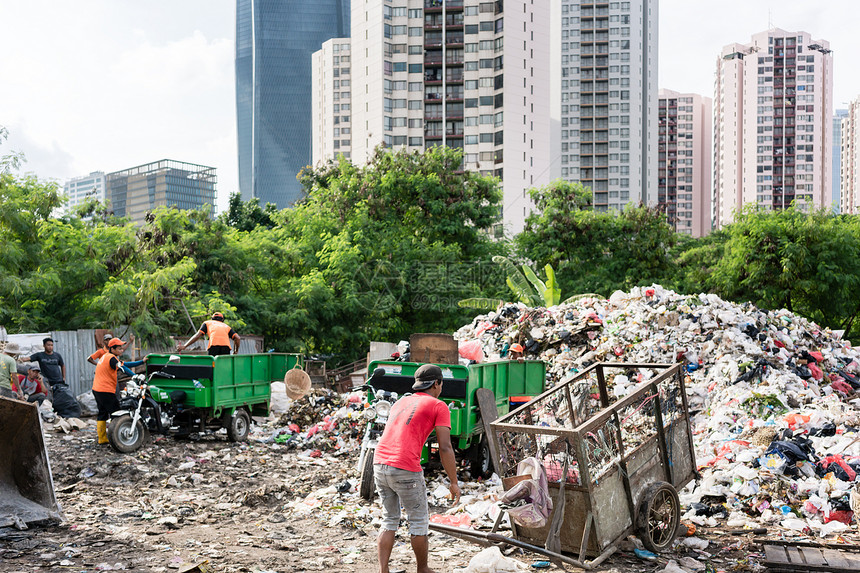 人们在雅加达摩天大楼现代区旁边的垃圾填埋场处图片