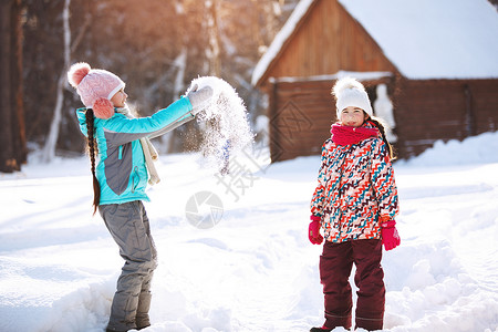 两个小女孩在冬季公园玩耍扔图片