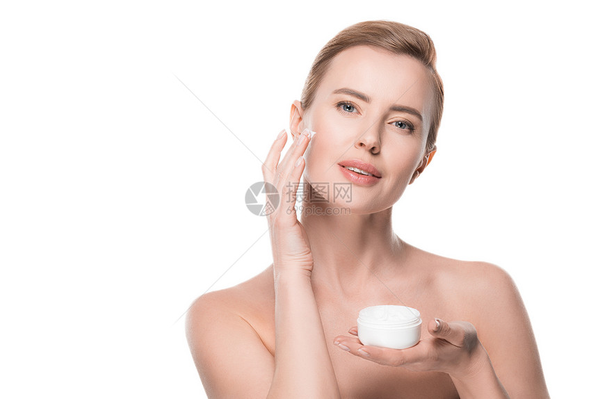 白皮肤清洁妇女将奶油涂在白脸上图片