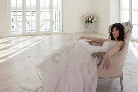 穿着婚纱的年轻女子在豪华的室内装饰着一大堆粉红色和白色的气球图片