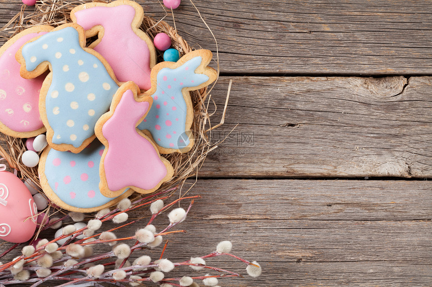 木桌上的复活节姜饼干兔子和鸡蛋贺卡顶层风图片