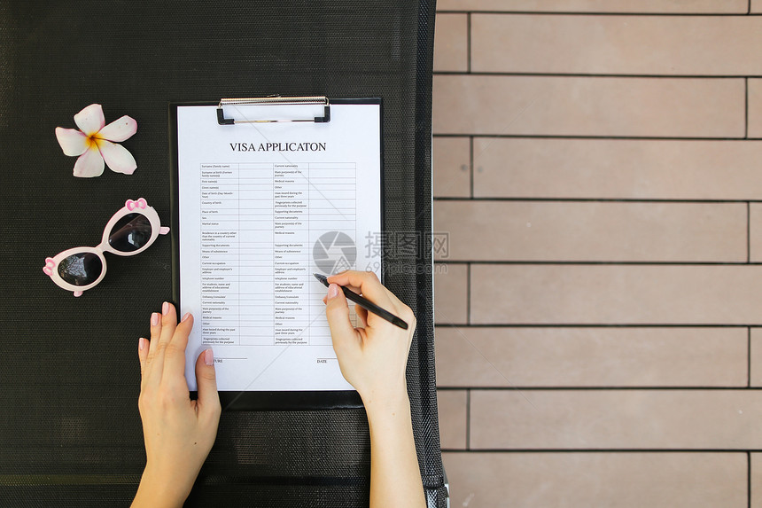 平躺的女人手填写商务旅行签证申请太阳镜和热带花卉的阳光肖像商务会议国际交图片