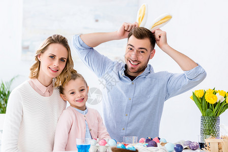 幸福的家庭在复活节以彩蛋和彩蛋桌边玩图片