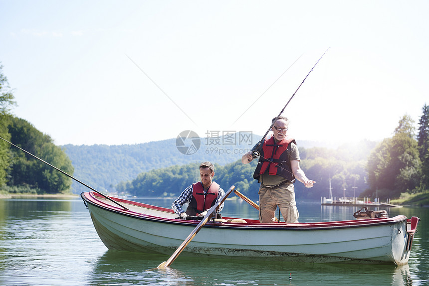 老人带着儿子在湖里钓鱼图片