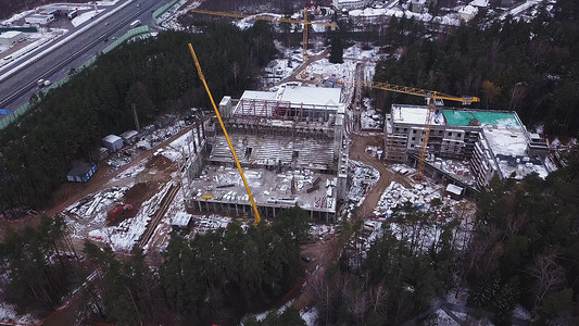 一个大型建筑工地的鸟瞰图住宅高层建筑和建筑起重机在冬天建造高层图片