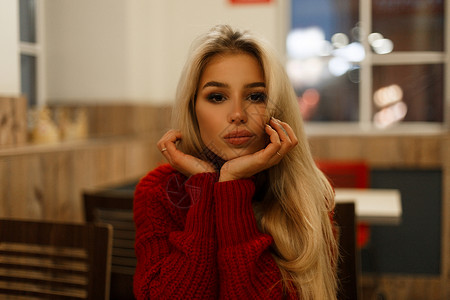 穿着时装红毛衣的年轻美女晚上图片