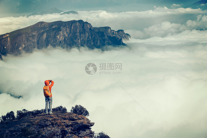 成功的徒步旅行者在山顶拍照图片